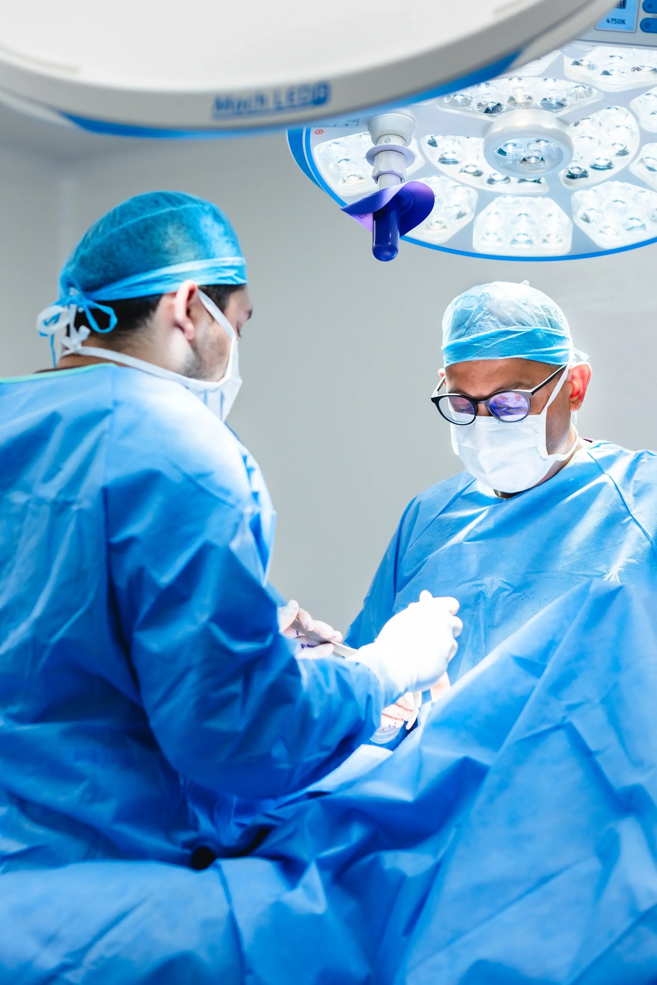 Surgeons performing surgery in operating room with advanced medical equipment