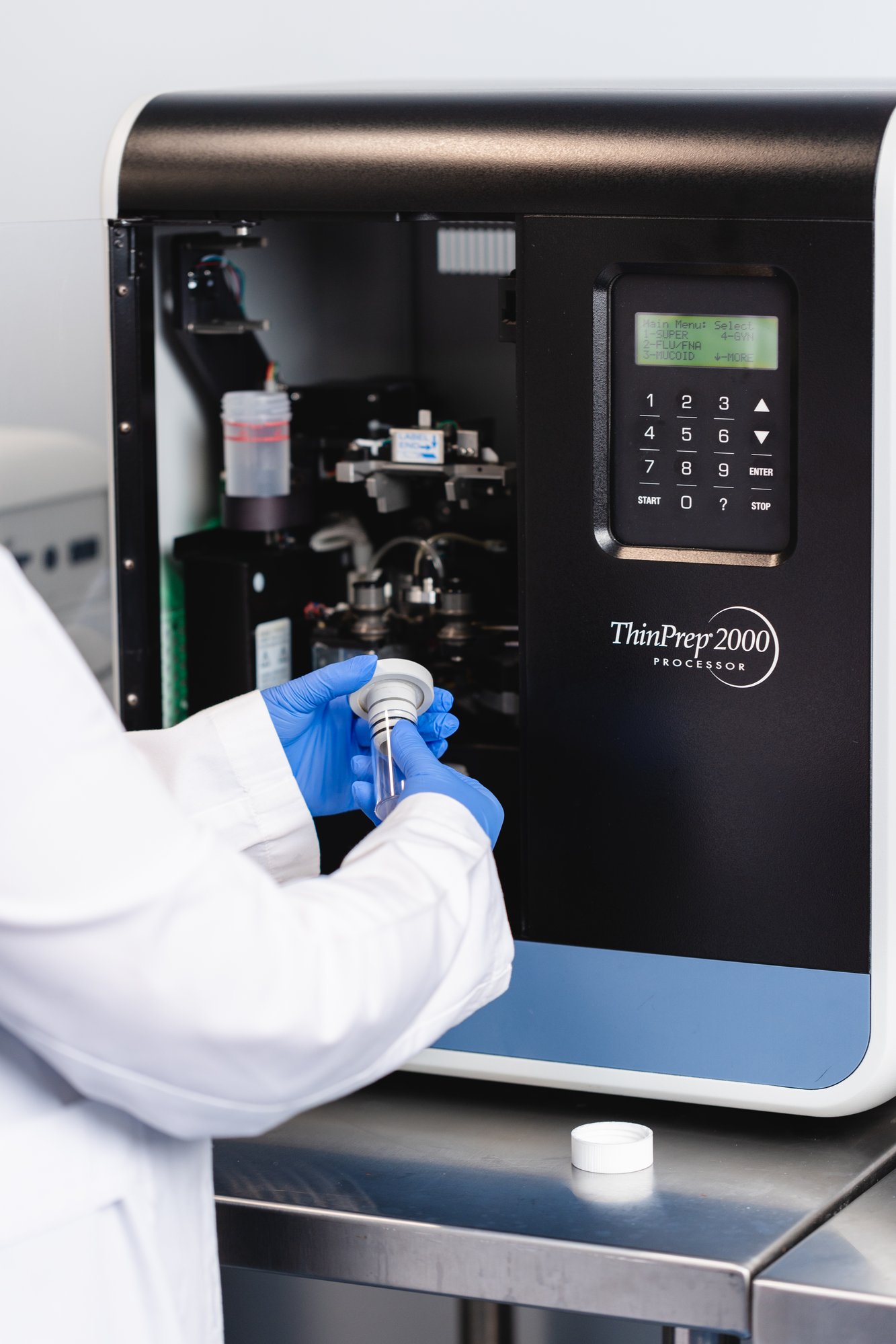 Scientist handling sample on ThinPrep 2000 machine in clinical laboratory