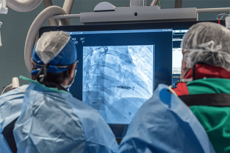 Médicos observando imagen de rayos X durante procedimiento quirúrgico