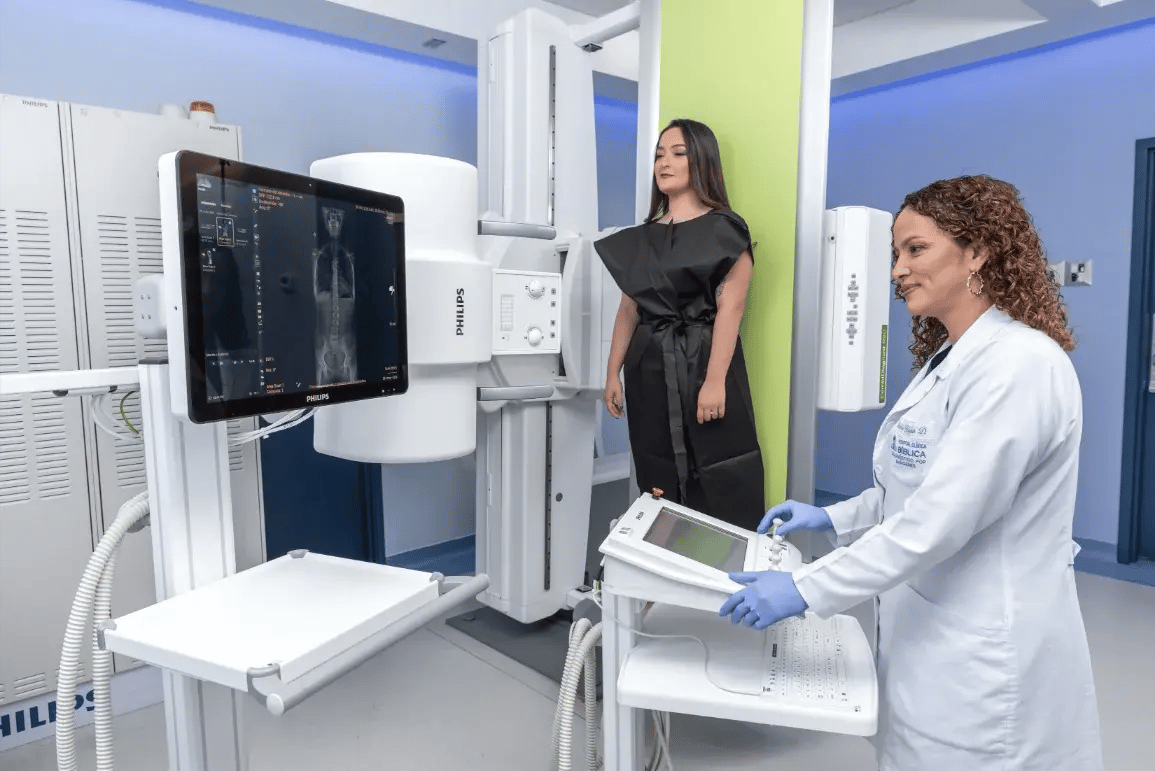 Técnica radiológica realizando estudio de rayos X a paciente de pie