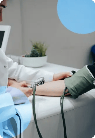 Persona tomando la presión arterial a un paciente con un esfigmomanómetro en el brazo.