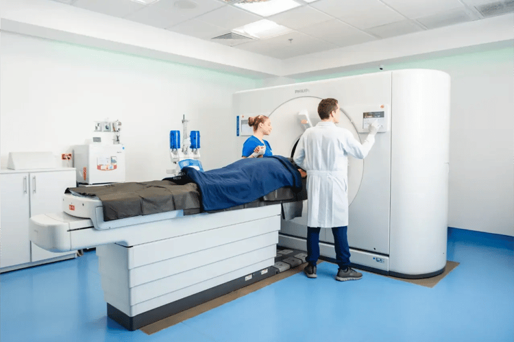 Patient receiving a CT scan assisted by medical staff