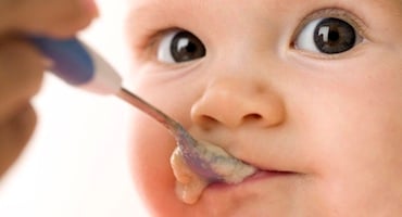 Bebé comiendo papilla con cuchara