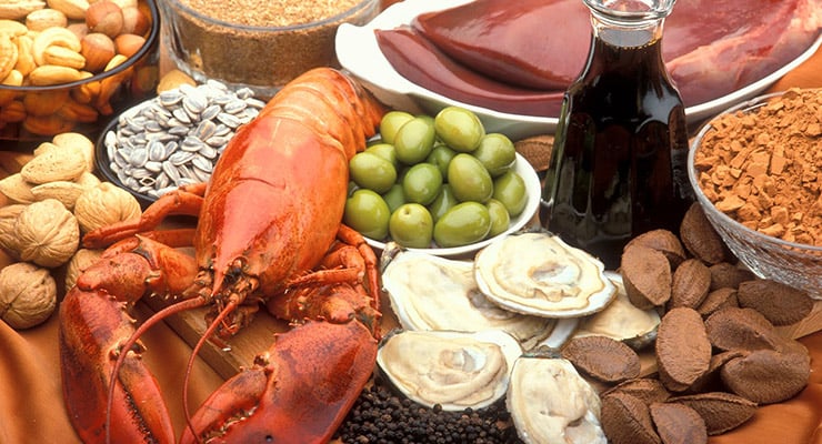 Variedad de alimentos como mariscos, frutos secos, aceitunas y otros ingredientes sobre una mesa