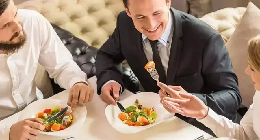 Grupo de personas compartiendo ensalada saludable en almuerzo de trabajo