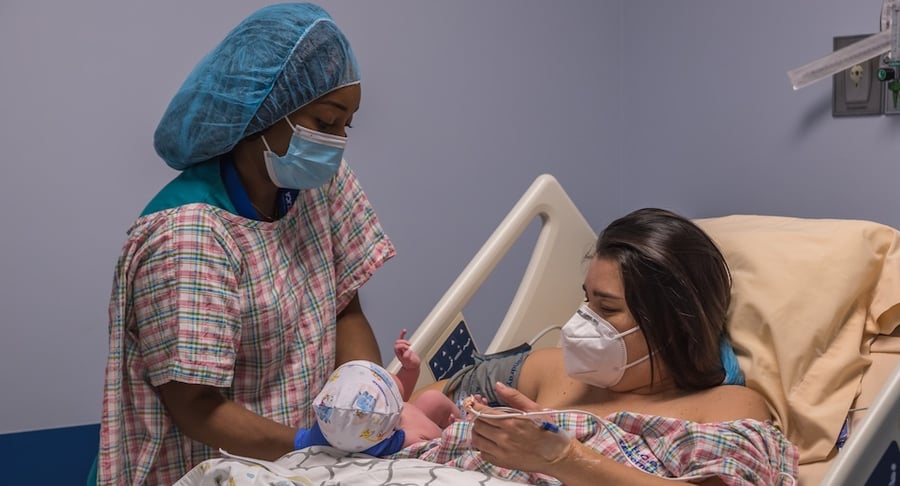 Personal de salud acompaña a madre y recién nacido durante apego precoz en sala de maternidad