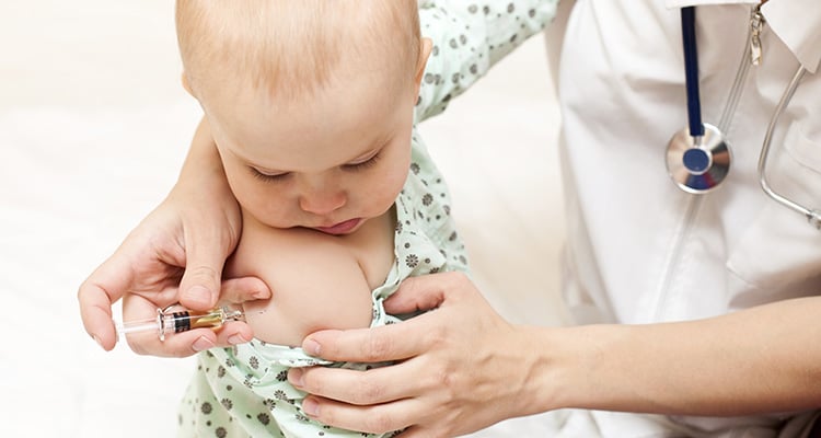 Profesional de la salud aplicando una vacuna en el brazo de un bebé