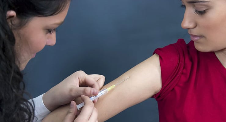 Profesional de la salud aplicando una vacuna en el brazo de una mujer