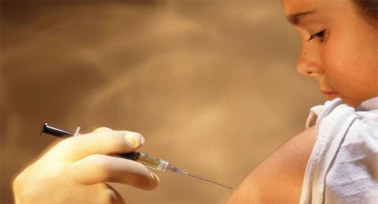 Personal de salud aplica una vacuna con jeringa en el brazo de una niña