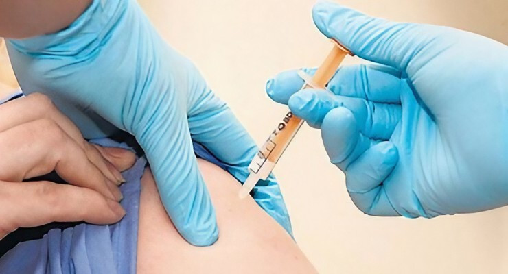 Aplicación de vacuna mediante inyección en el brazo con guantes médicos