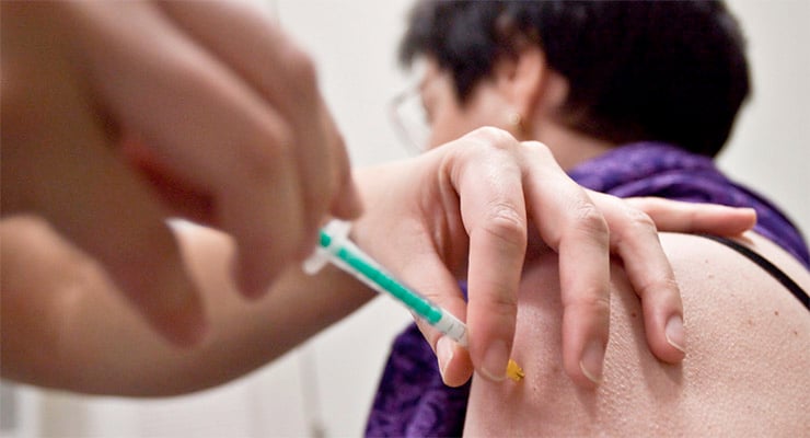Aplicación de vacuna en el brazo de una persona por personal de salud