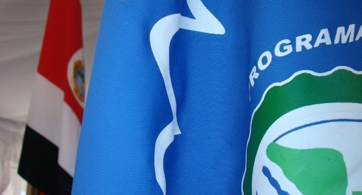 Bandera azul con logotipo y bandera de Costa Rica al fondo