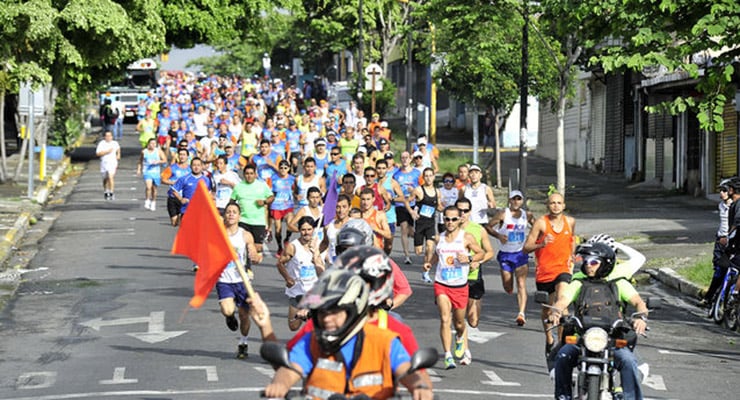 Grupo numeroso de personas participando en una carrera recreativa en la vía pública