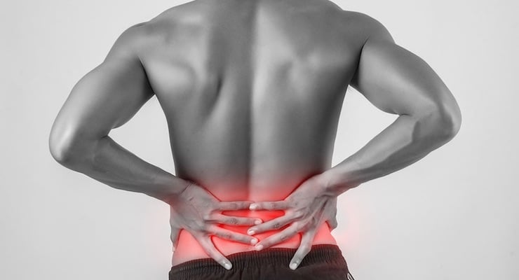 Hombre de espaldas sujetando la zona lumbar con ambas manos con resaltado rojo en la parte baja