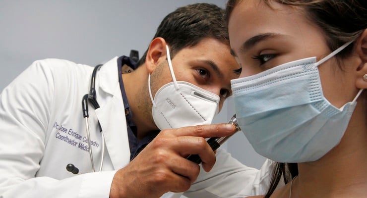 Médico del Hospital Clínica Bíblica realiza chequeo médico preventivo a una niña en consulta pediátrica