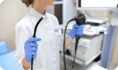 Especialista médica mostrando la punta iluminada de un endoscopio flexible en la sala de gastroenterología del Hospital Clínica Bíblica.