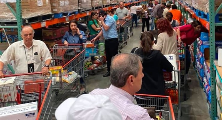 Personas con carritos de supermercado realizando compras en un almacén