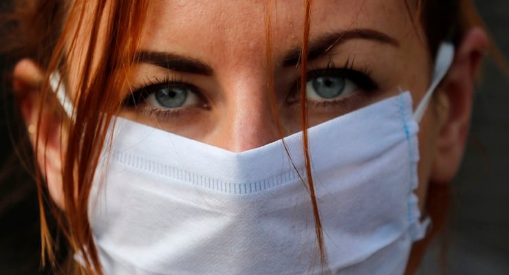 Mujer con mascarilla mostrando enrojecimiento en los ojos