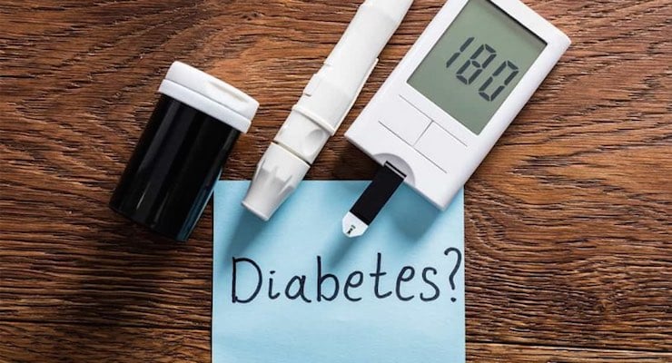 Glucómetro marcando 180 junto a un frasco de tiras reactivas y una nota que dice Diabetes