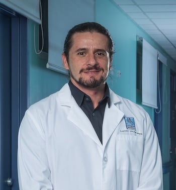 Médico especialista en neumología con bata blanca en pasillo hospitalario