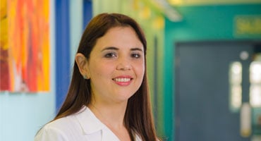 Doctora con bata blanca en pasillo de centro médico
