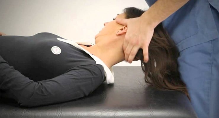 Mujer recostada en camilla mientras un fisioterapeuta realiza manipulación en cuello y cabeza.