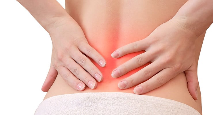 Manos presionando la zona lumbar de la espalda baja con un área resaltada que indica dolor.