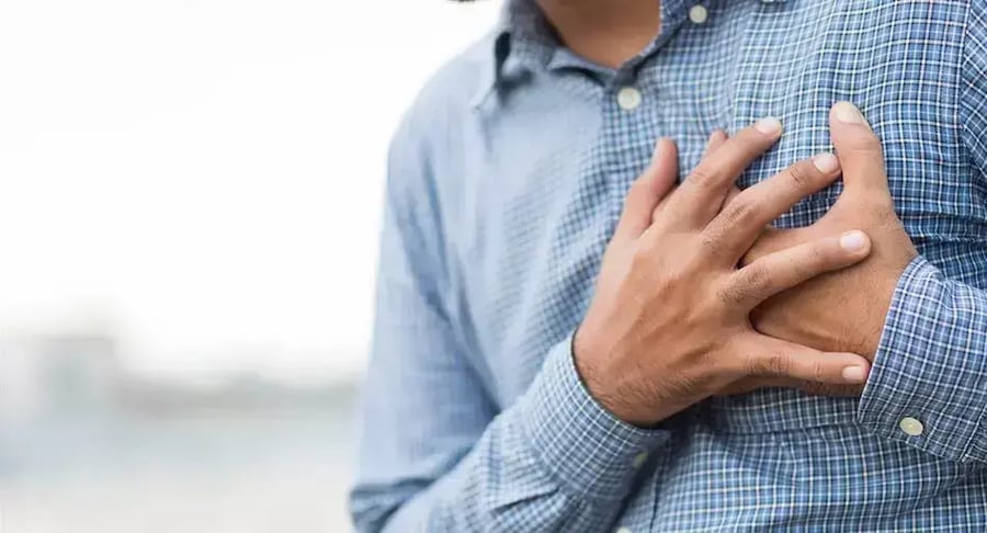 Hombre con dolor en el pecho, posible síntoma de infarto o problema cardíaco