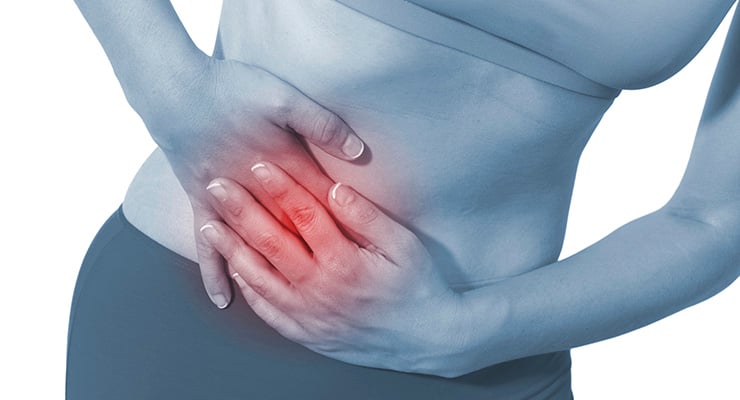 Mujer sujetando el abdomen bajo con las manos, con zona resaltada en rojo que indica dolor pélvico.