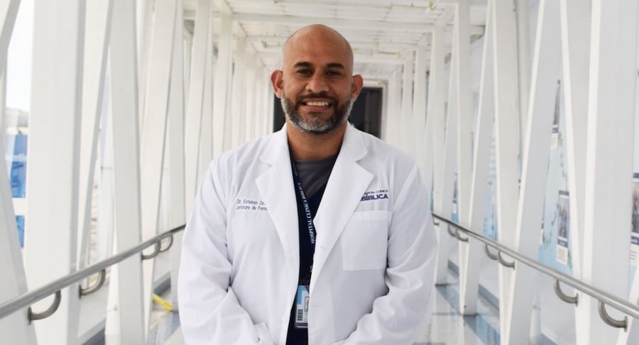 Dr. Esteban Zavaleta, jefe de Farmacia del Hospital Clínica Bíblica, posando con bata médica en un pasillo del hospital.