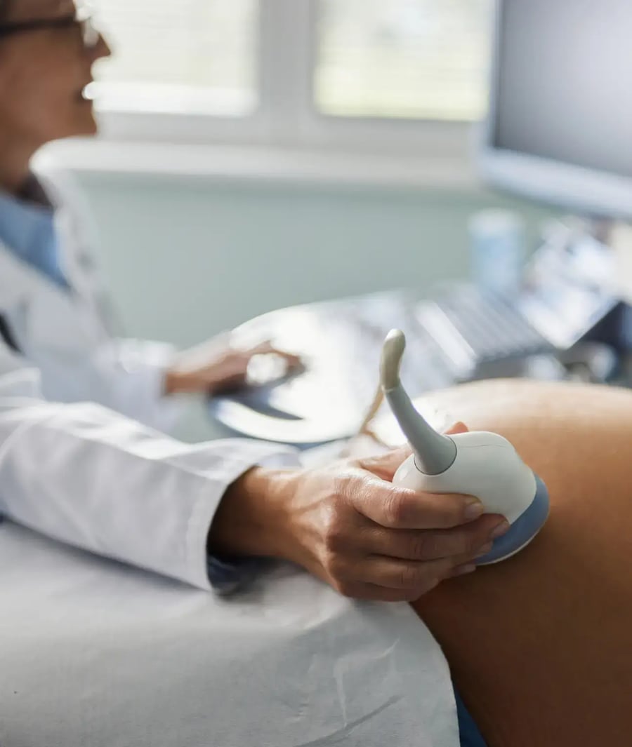 Médico realizando ultrasonido prenatal a mujer embarazada en la Clínica Bíblica.