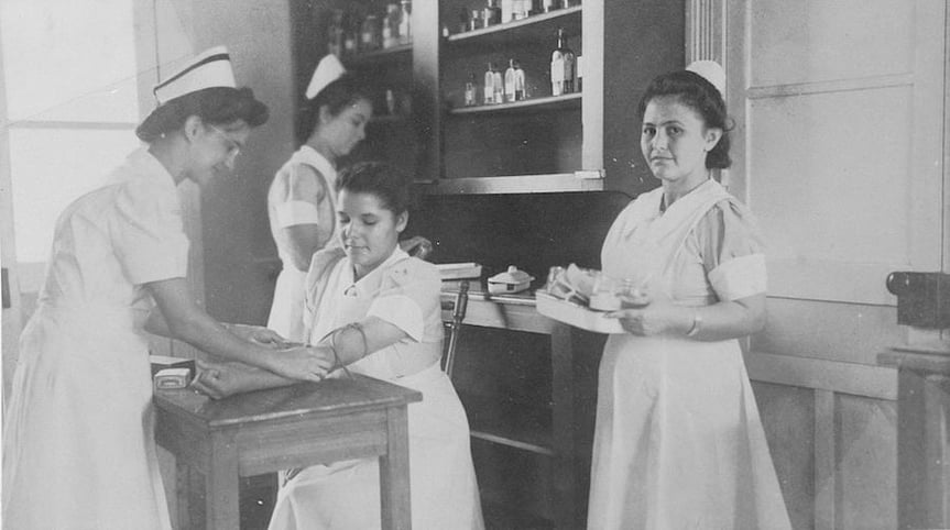 Enfermeras del Hospital Clínica Bíblica realizando atención clínica en un laboratorio, fotografía histórica.