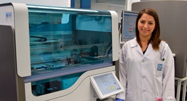 La Dra. Karla Gutiérrez, especialista en biología molecular, junto al sofisticado equipo MagNA Pure 24 en el laboratorio clínico.