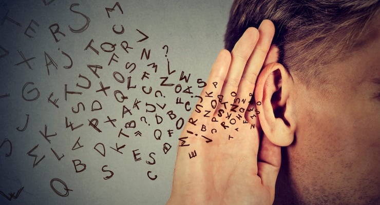 Persona colocando la mano detrás de la oreja en gesto de intentar escuchar mejor