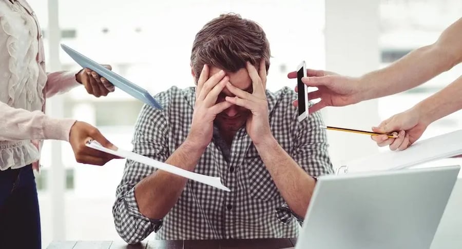 Hombre estresado en la oficina con exceso de trabajo y múltiples responsabilidades