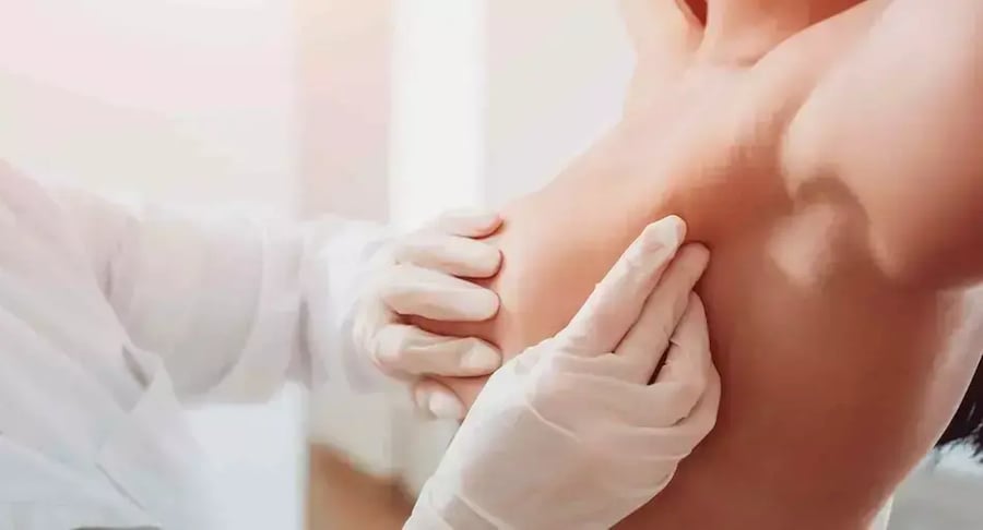 Doctora realizando examen clínico de mama a paciente mujer