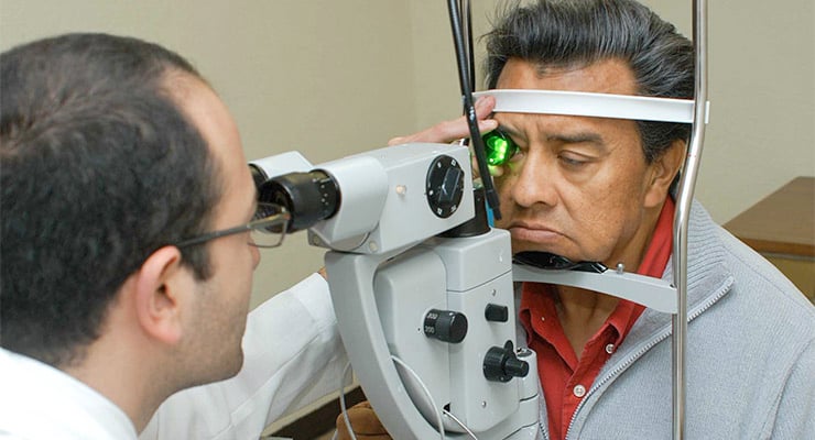Paciente realizando un examen de la vista con equipo oftalmológico en consulta médica.