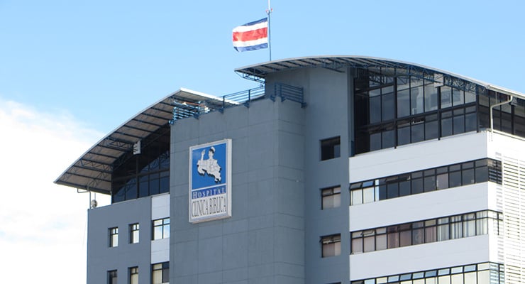 Fachada del Hospital Clínica Bíblica con bandera de Costa Rica en la parte superior del edificio.