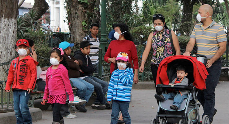 Familias caminando en un parque con mascarillas protectoras