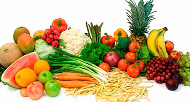 Gran variedad de frutas y verduras frescas, como piña, banano, uvas y vegetales verdes, que representan una alimentación saludable para el cerebro.