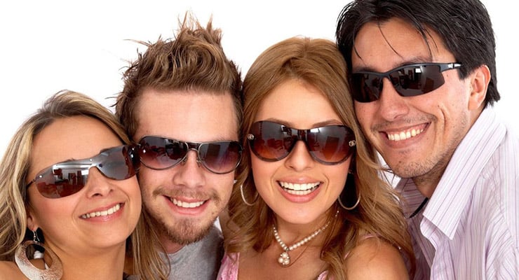 Grupo de personas sonriendo y usando lentes de sol frente a la cámaraGrupo de personas sonriendo y usando lentes de sol frente a la cámara