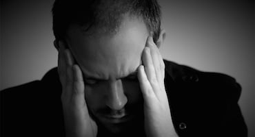Hombre con las manos en la cabeza y expresión de angustia
