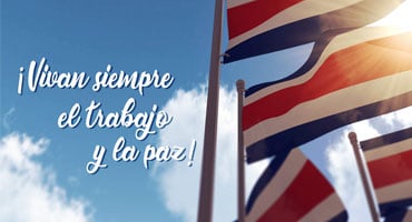 Banderas de Costa Rica ondeando al sol con el lema ¡Vivan siempre el trabajo y la paz!, en conmemoración del mes de la patria.