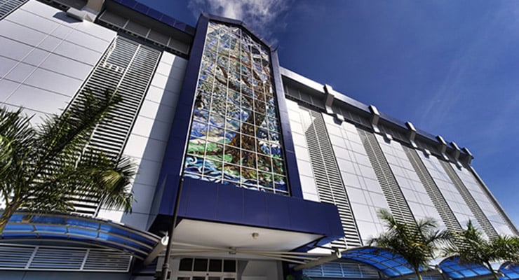 Fachada del Hospital Clínica Bíblica con vitral central y palmeras