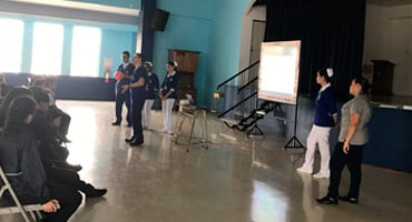 Personal de la Dirección de Enfermería del Hospital Clínica Bíblica impartiendo una charla educativa sobre prevención y salud a estudiantes de escuela.