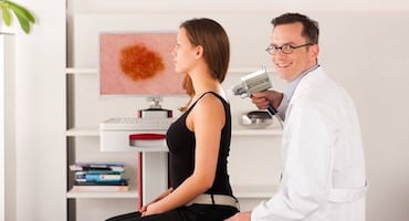 Especialista utilizando el equipo Foto Finder para el mapeo automatizado de lunares y detección temprana de cáncer de piel en una paciente.