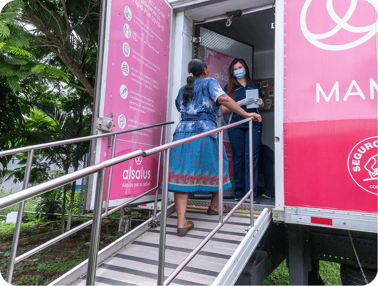 Unidad móvil de salud con rampa de acceso y paciente ingresando.