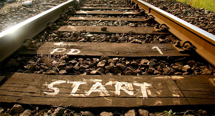 Vía del tren con la palabra “START” escrita sobre los durmientes, simbolizando el inicio de un camino.