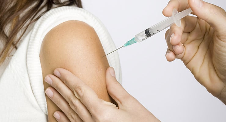 Aplicación de una inyección en el brazo de una persona