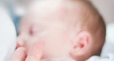 Bebé recién nacido siendo amamantado por su madre en contacto cercano